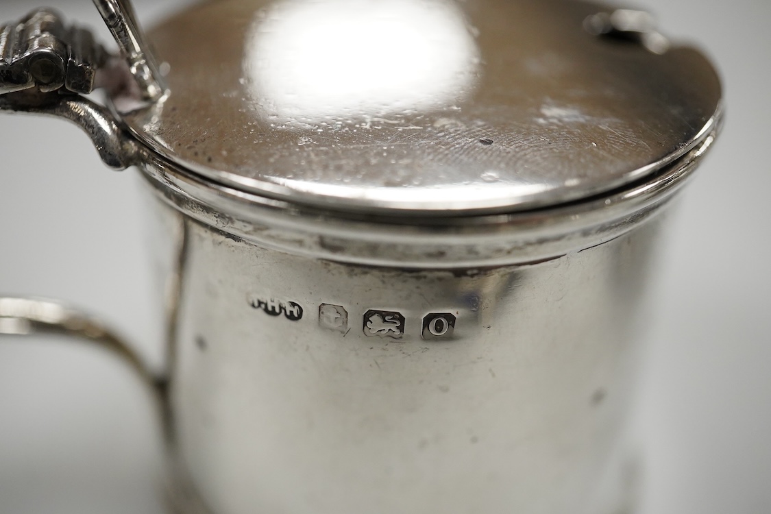 An ornate Edwardian silver oval mustard pot and matching spoon by Barker Brothers, Birmingham, 1902, length, 95mm, together with five other assorted silver condiments including a pair of pierced oval salts with blue glas